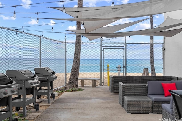 view of patio with area for grilling, a water view, and outdoor lounge area