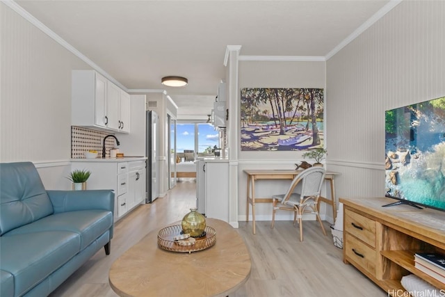 living room featuring crown molding, light hardwood / wood-style floors, and sink