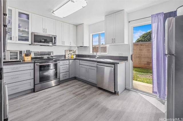 kitchen featuring white cabinets, stainless steel appliances, a healthy amount of sunlight, and sink