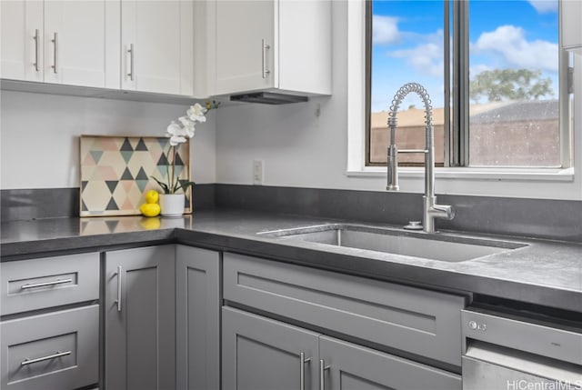 kitchen with white cabinetry, gray cabinetry, dishwashing machine, and sink