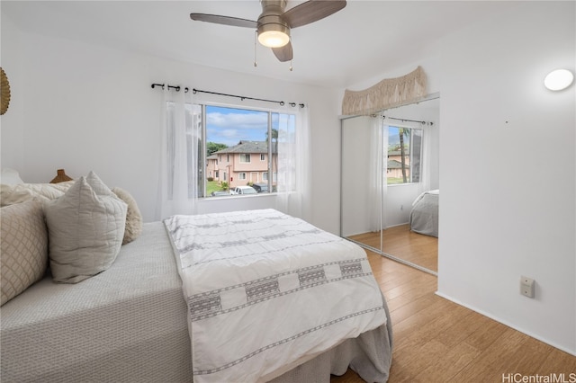 bedroom with ceiling fan, a closet, and light hardwood / wood-style flooring