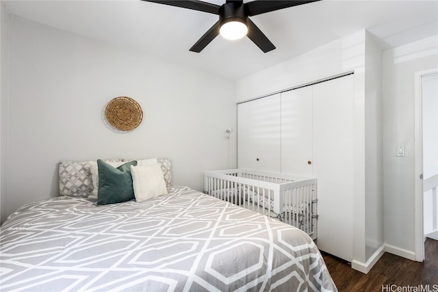 bedroom with a closet, dark wood-type flooring, and ceiling fan