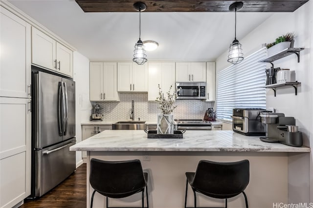 kitchen featuring light stone counters, stainless steel appliances, white cabinetry, and sink