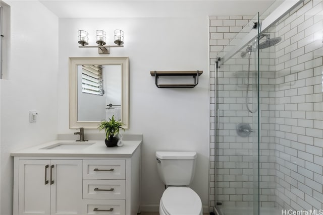 bathroom with vanity, toilet, and a shower with shower door