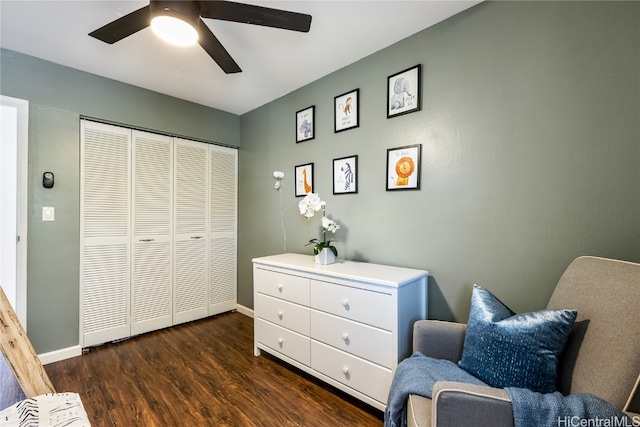 living area featuring ceiling fan and dark hardwood / wood-style flooring