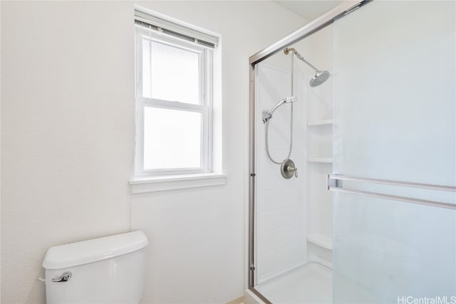 bathroom featuring toilet and a shower with door