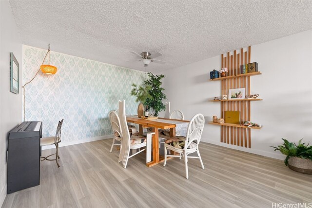 dining space featuring a textured ceiling, light wood-type flooring, and ceiling fan