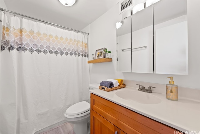 bathroom with vanity, toilet, and wood-type flooring