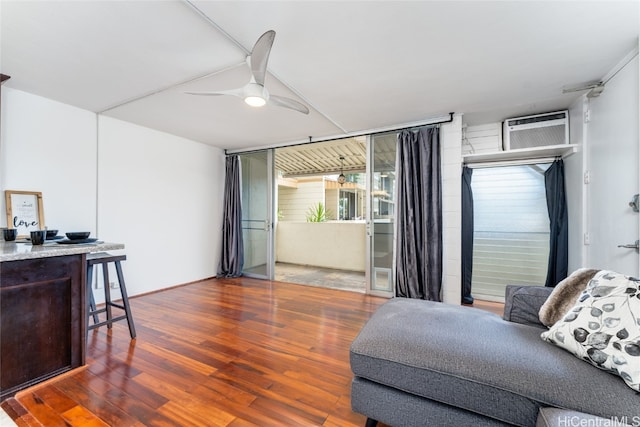 living room featuring ceiling fan, a wall unit AC, and dark hardwood / wood-style floors