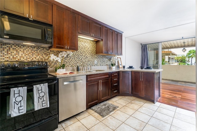 kitchen featuring light tile patterned flooring, sink, black appliances, and tasteful backsplash