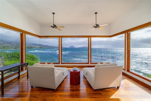 sunroom featuring ceiling fan and a water and mountain view