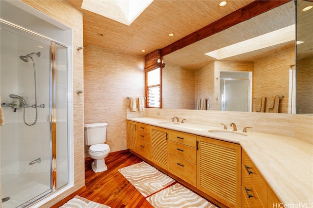 bathroom with vanity, toilet, wood-type flooring, and a shower with door