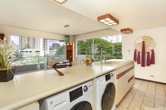 washroom with light tile patterned floors, sink, and washing machine and clothes dryer