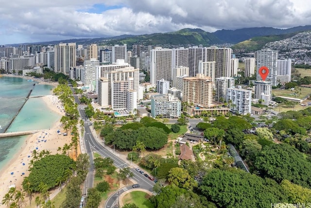 drone / aerial view with a water and mountain view and a beach view