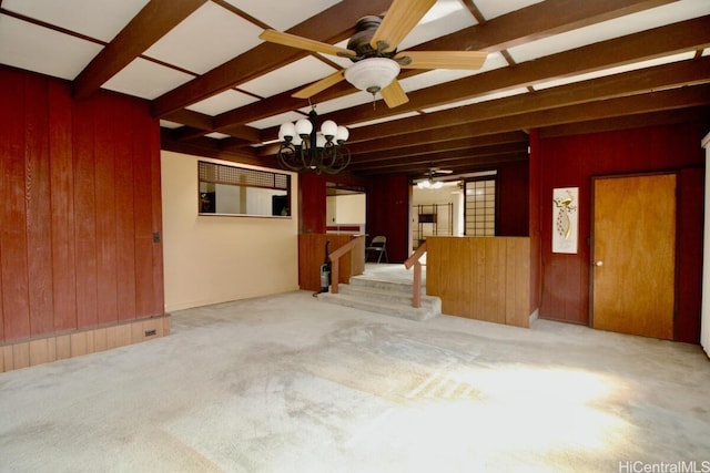 carpeted empty room with beamed ceiling, wooden walls, and a chandelier