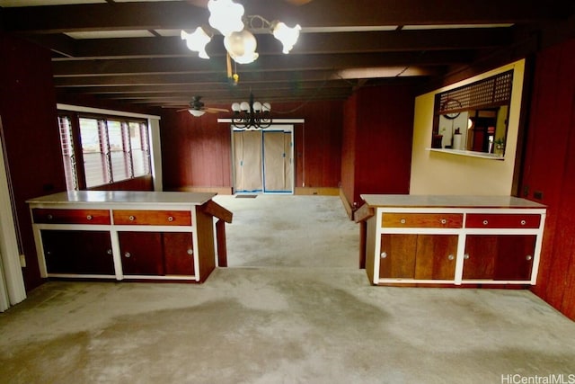 interior space featuring beam ceiling, wooden walls, light carpet, and ceiling fan with notable chandelier