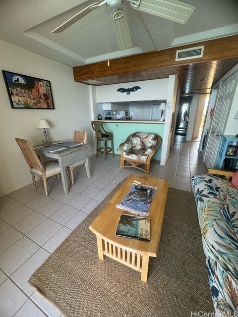 tiled living room featuring ceiling fan