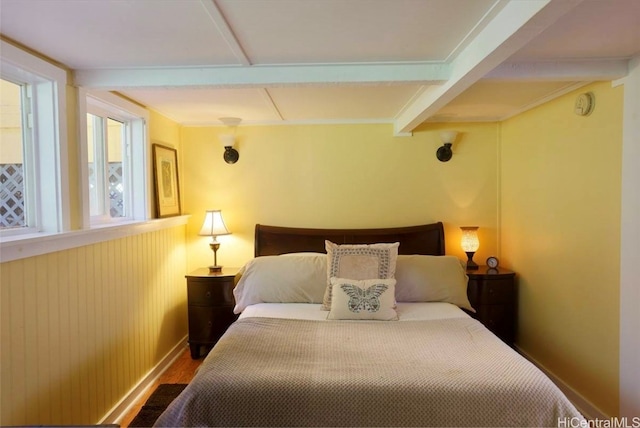 bedroom with beamed ceiling and wood-type flooring