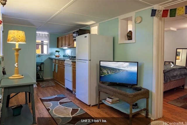 kitchen featuring white appliances and wood-type flooring