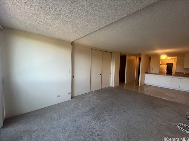 interior space with a textured ceiling and light carpet