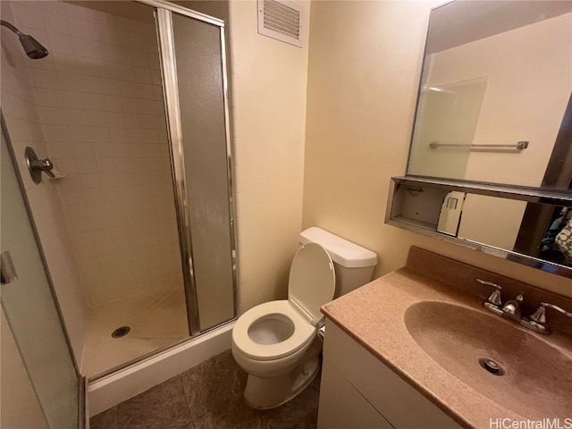 bathroom with toilet, vanity, tile patterned floors, and a shower with shower door