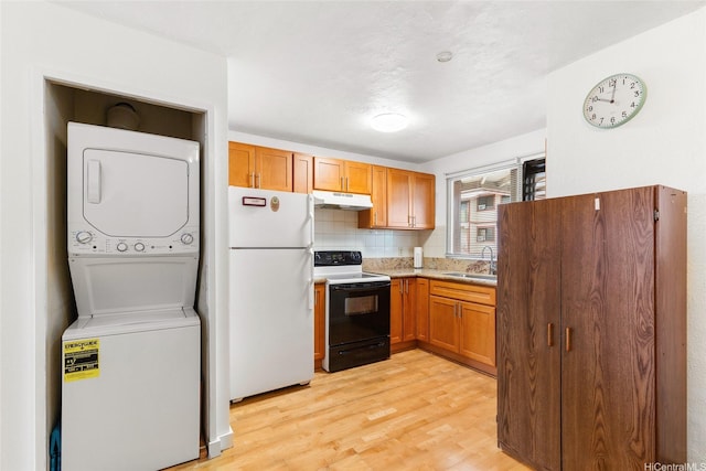98-626 Moanalua Loop Unit 311, Aiea, HI 96701 - kitchen featuring freestanding refrigerator, electric range, under cabinet range hood, stacked washing machine and dryer, and light wood-type flooring
