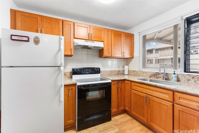 kitchen with white appliances, sink, light hardwood / wood-style flooring, decorative backsplash, and light stone countertops