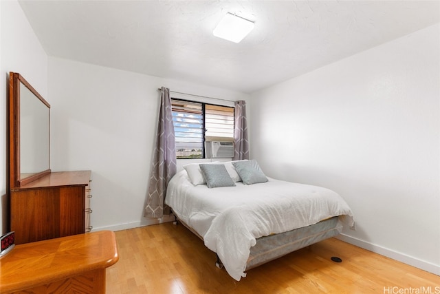 bedroom featuring cooling unit and light wood-type flooring