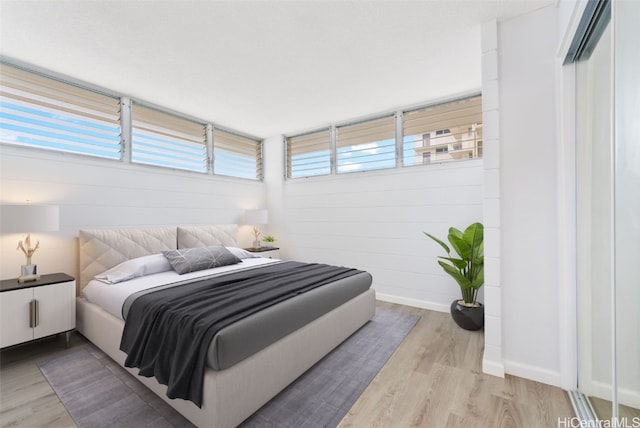 bedroom with light wood-type flooring and multiple windows