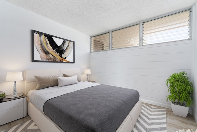 bedroom featuring a textured ceiling and light hardwood / wood-style floors