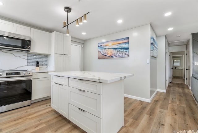 kitchen featuring appliances with stainless steel finishes, decorative light fixtures, light hardwood / wood-style floors, and white cabinets