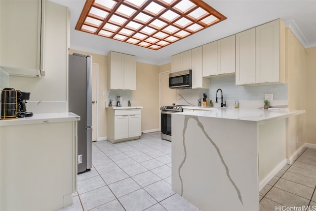 kitchen with light tile patterned flooring, crown molding, appliances with stainless steel finishes, and tasteful backsplash