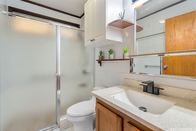 bathroom with toilet, vanity, and an enclosed shower