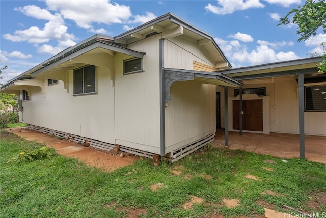 view of side of property featuring a yard and a patio