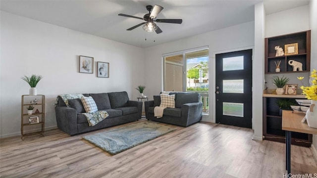 living room featuring ceiling fan and light hardwood / wood-style flooring