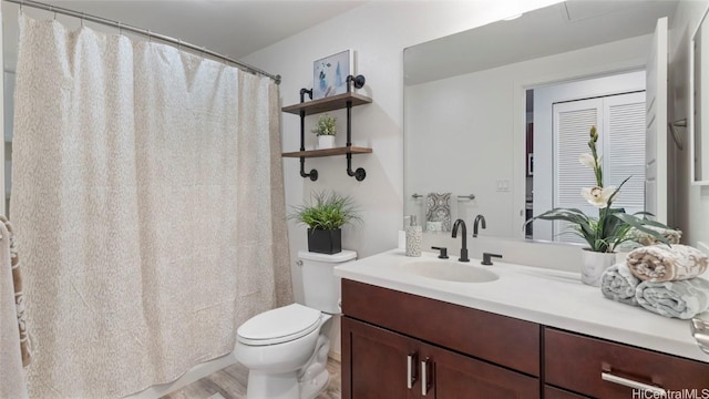 bathroom with hardwood / wood-style flooring, vanity, and toilet