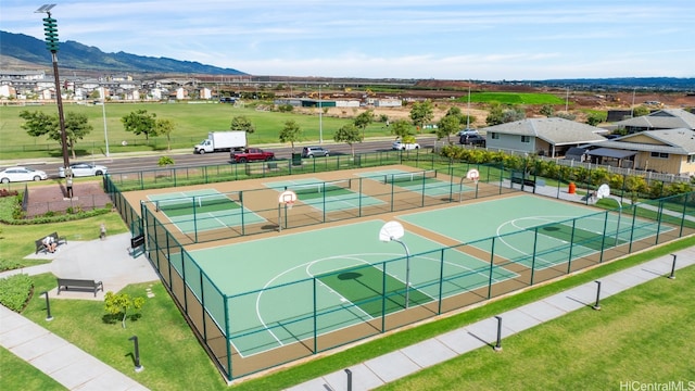 view of sport court featuring a mountain view, tennis court, and a yard