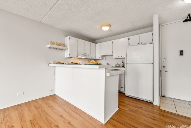 kitchen with white cabinets, kitchen peninsula, light hardwood / wood-style flooring, and white appliances