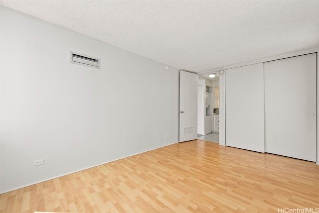 unfurnished bedroom with a closet, a textured ceiling, and light hardwood / wood-style flooring