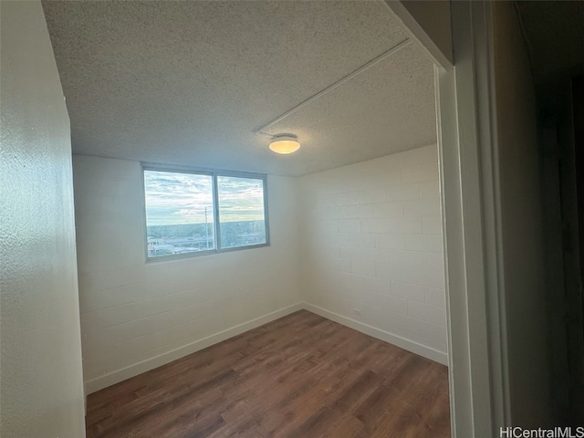 unfurnished room with dark hardwood / wood-style flooring and a textured ceiling