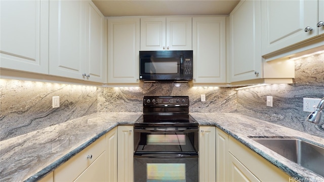 kitchen featuring sink, backsplash, black appliances, and white cabinets