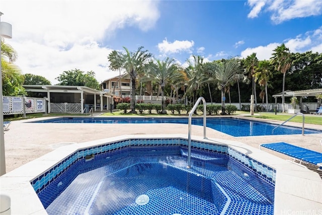 view of swimming pool featuring a hot tub