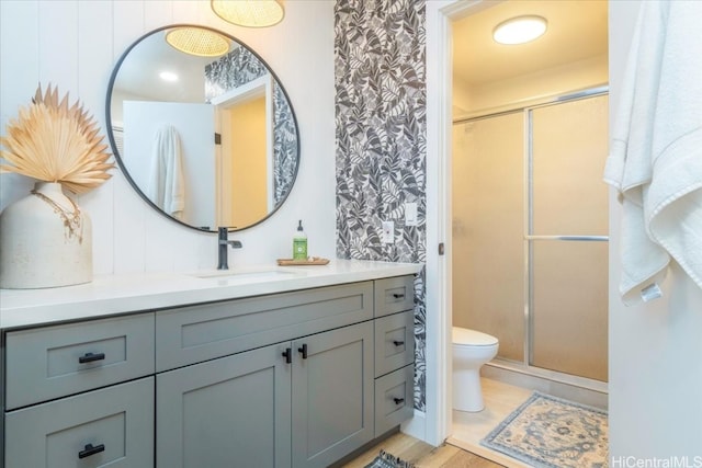 bathroom featuring hardwood / wood-style floors, an enclosed shower, vanity, and toilet