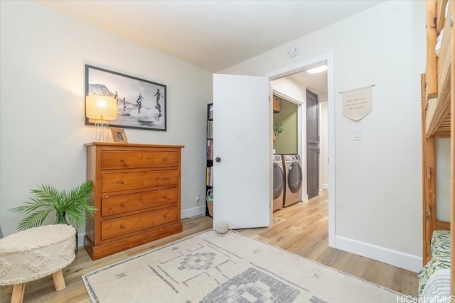 bedroom with light wood-type flooring and washing machine and dryer