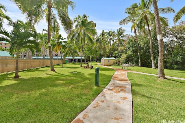 view of home's community featuring a lawn and a storage shed