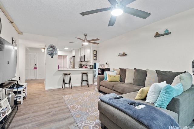 living room featuring light hardwood / wood-style floors and a textured ceiling