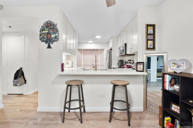 1080 Ala Napunani St Unit 403, Honolulu, HI 96818 - kitchen with refrigerator, stove, stainless steel microwave, and a breakfast bar