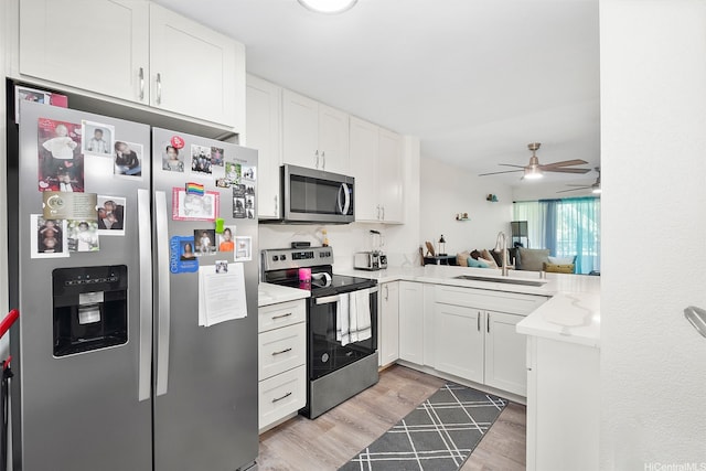 1080 Ala Napunani St Unit 403, Honolulu, HI 96818 - kitchen featuring appliances with stainless steel finishes, ceiling fan, white cabinets, light wood-style flooring, and a peninsula