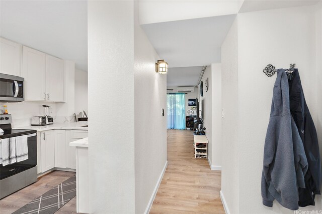 1080 Ala Napunani St Unit 403, Honolulu, HI 96818 - kitchen featuring appliances with stainless steel finishes, light wood-style flooring, light countertops, and white cabinetry