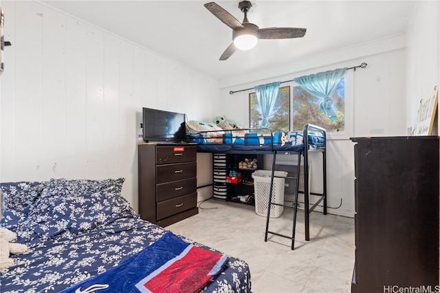 bedroom with ceiling fan, wooden walls, and crown molding